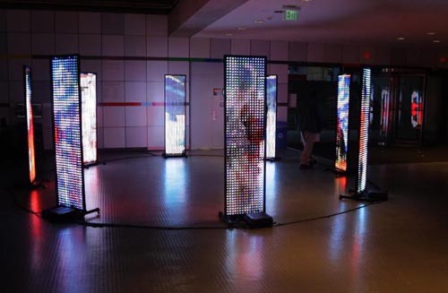 8 LED screens in a circle displaying color abstract content