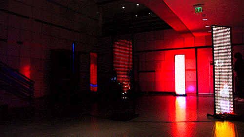 alt="8 LED screens in a circle displaying red abstract content"