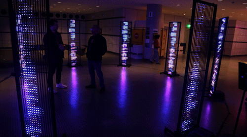 8 LED screens in a circle displaying blue and text and with people